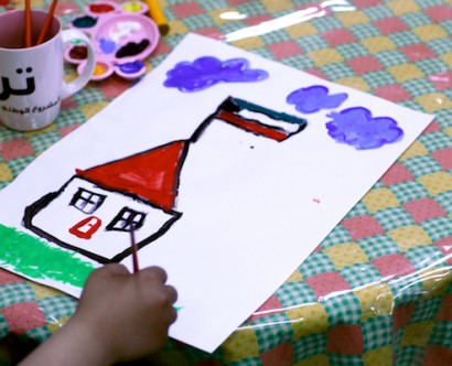 Child painting of Kuwait flag on a house.
